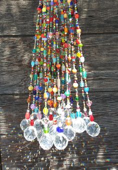 a multicolored chandelier hanging from a wooden ceiling with beads and glass balls