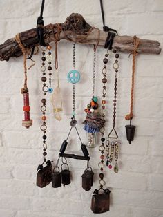 there are many different items hanging on the wall with chains and bells attached to them