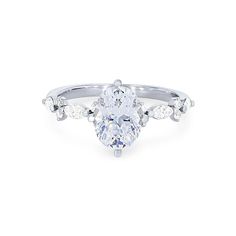 a pear shaped diamond engagement ring with three stones on the band and an oval center stone