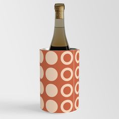 a bottle of wine in an orange and white polka dot pattern canister with cork stopper