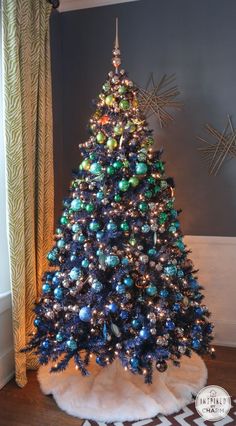 a blue christmas tree in the corner of a room