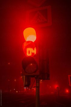 a red stop light with the word oh written on it at night time by jodi lenski for stocksy photography