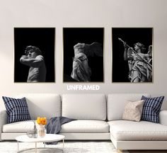 three black and white paintings on the wall above a couch