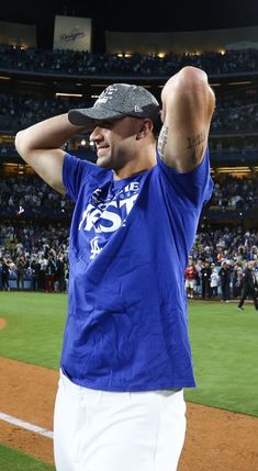 a man in blue shirt and white pants on baseball field