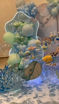 a table topped with lots of balloons and animals on top of it's sides