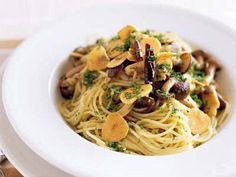 pasta with mushrooms and broccoli in a white bowl