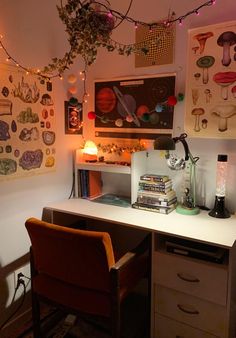 a desk with two chairs and some pictures on the wall