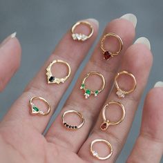 a person's hand with five different rings on it