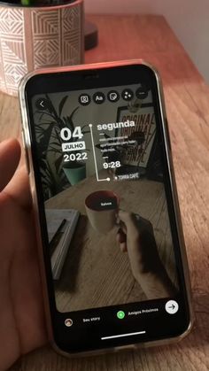 someone is holding their cell phone with the screen showing an image of a coffee cup
