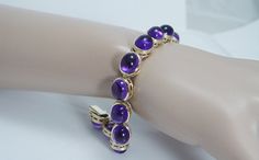 Visit the store of our partners here - https://www.etsy.com/shop/jewelsdirect?ref=search_shop_redirect  For most of our items more pictures available. This gorgeous estate bracelet is finely crafted in solid 14K Yellow gold and it is set with genuine Earth mined Amethyst cabochons. Each gem is 10mmx 8mm for the total weight 32.06 carats. These cabochons are great quality stones of a good intensity.  The bracelet is 7 inches long and8mm thick. Perfectly working clasp. ... Formal Amethyst Round Bracelets, Formal Round Amethyst Bracelets, Formal Amethyst Bracelets, Elegant Amethyst Bracelet, Purple Round Tennis Bracelet For Formal Occasions, Purple Princess, Everyday Bracelet, Purple Bracelet, Elegant Bracelet