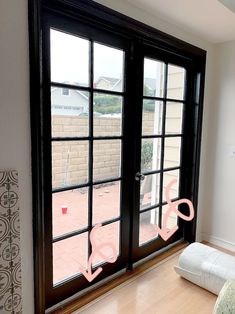 an empty room with two double doors and a pink ribbon on the window sill