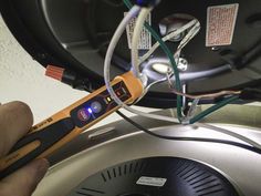 an electrician is checking the current in his electrical device, which is connected to wires and plugs