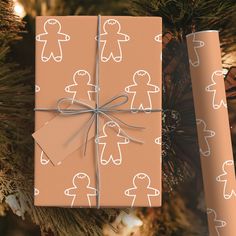 a present wrapped in brown paper on top of a christmas tree next to a gift wrapper