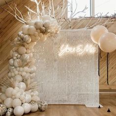 balloons are arranged on the floor in front of a white wall and wooden paneled walls