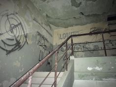 graffiti on the wall and stairs in an abandoned building