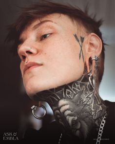 a woman with tattoos and piercings on her neck