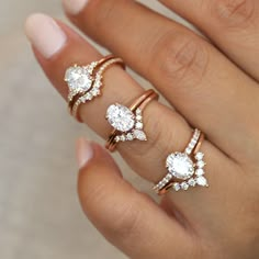 a woman's hand with three different rings on her fingers and one has an engagement ring