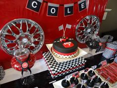 a birthday party with red, black and white decor including a cake in the shape of a car