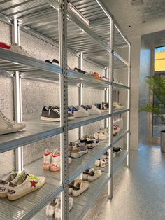 there are many pairs of shoes that are on the shelves in this room and one is empty