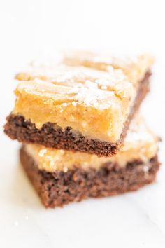 two pieces of brownie with powdered sugar on top and one piece cut in half