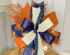 an orange, blue and white bow sitting on top of a wooden table