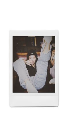 a polaroid photo of a woman laying on the floor with her legs up in the air