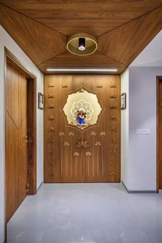 an entry way with wooden doors and decorative artwork on the door paneling, along with white walls