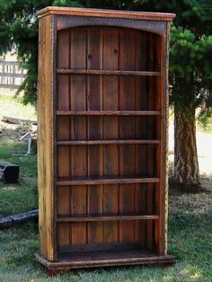 an old wooden bookcase sitting in the grass