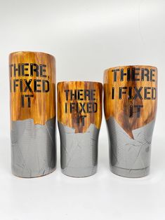 three wooden cups with words painted on them