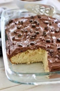 a cake with chocolate frosting on top in a glass baking dish, ready to be eaten