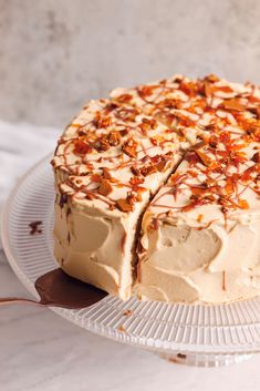 a cake with white frosting and chopped nuts on top