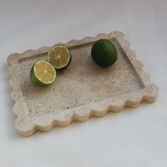 two limes and a lemon on a tray