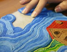 a person is working on an art project with colored lines and shapes that look like waves