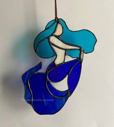 a stained glass mermaid hanging from a hook