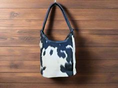 Indulge in the opulence of this exquisite black and white cowhide leather bucket bag by Custom Jackets n Bags. Designed to be roomy and adaptable, it features a magnetic fastening, internal zip pocket with canvas lining. Handcrafted with exceptional skill, this carry-all shoulder bag is ideal for the contemporary woman on the move. Elevate your style with this remarkable accessory. 1- black & White Cowhide. 2- Natural black Leather. 3- Magnetic Main opening. 4- 1 small zip pocket inside. 5- Mobi Black Calf Hair Bags For Everyday Use, Black Calf Hair Bag For Everyday Use, Everyday Black Calf Hair Bag, Rectangular Calf Hair Shoulder Bag For Everyday Use, Black Calf Hair Shoulder Bag For Everyday Use, Rectangular Calf Hair Shoulder Bag For Everyday, Everyday Rectangular Calf Hair Shoulder Bag, Black Calf Hair Bag With Leather Handles, Calf Hair Satchel Bag