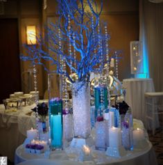 the centerpiece is decorated with blue branches and candles