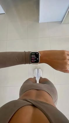 a person with an apple watch on their wrist and leg in the middle of the floor