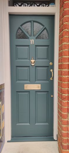 a blue front door with two sidelights and an arched glass window above the door