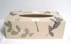 a tissue box with flowers and leaves painted on it