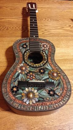 a colorful guitar sitting on top of a wooden table