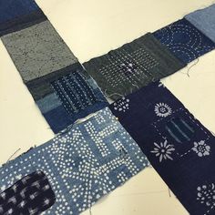 several pieces of blue and grey fabric laid out on a table