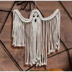 there is a white macrame with fringes hanging from it's side