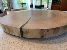 a large wooden table top sitting on top of a white marble countertop in a living room