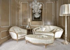 an elegant living room with chandelier and two chairs