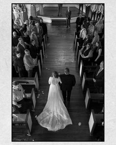 a black and white photo of a bride and groom walking down the aisle