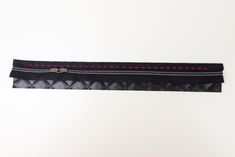 a black belt with pink stitching on it