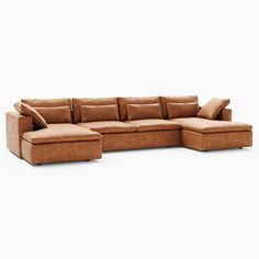 a large sectional couch with pillows on it's back and side facing the camera