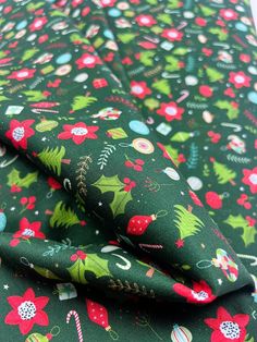 the fabric is green with red and green christmas decorations on it, as well as candy canes