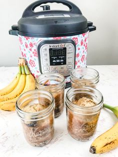 four jars filled with food sitting next to bananas and an instant pot on a table