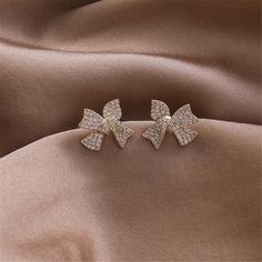 Tie together your ensembles with the classic style of these bow-shaped stud earrings crafted with 18k gold plating and cubic zirconia. 0.67'' W x 0.59'' H 18k gold-plated copper / cubic zirconia Earring Crafts, Gold Plating, Diamond Bracelet, Cubic Zirconia, Classic Style, 18k Gold, Gold Plate, Copper, Plating